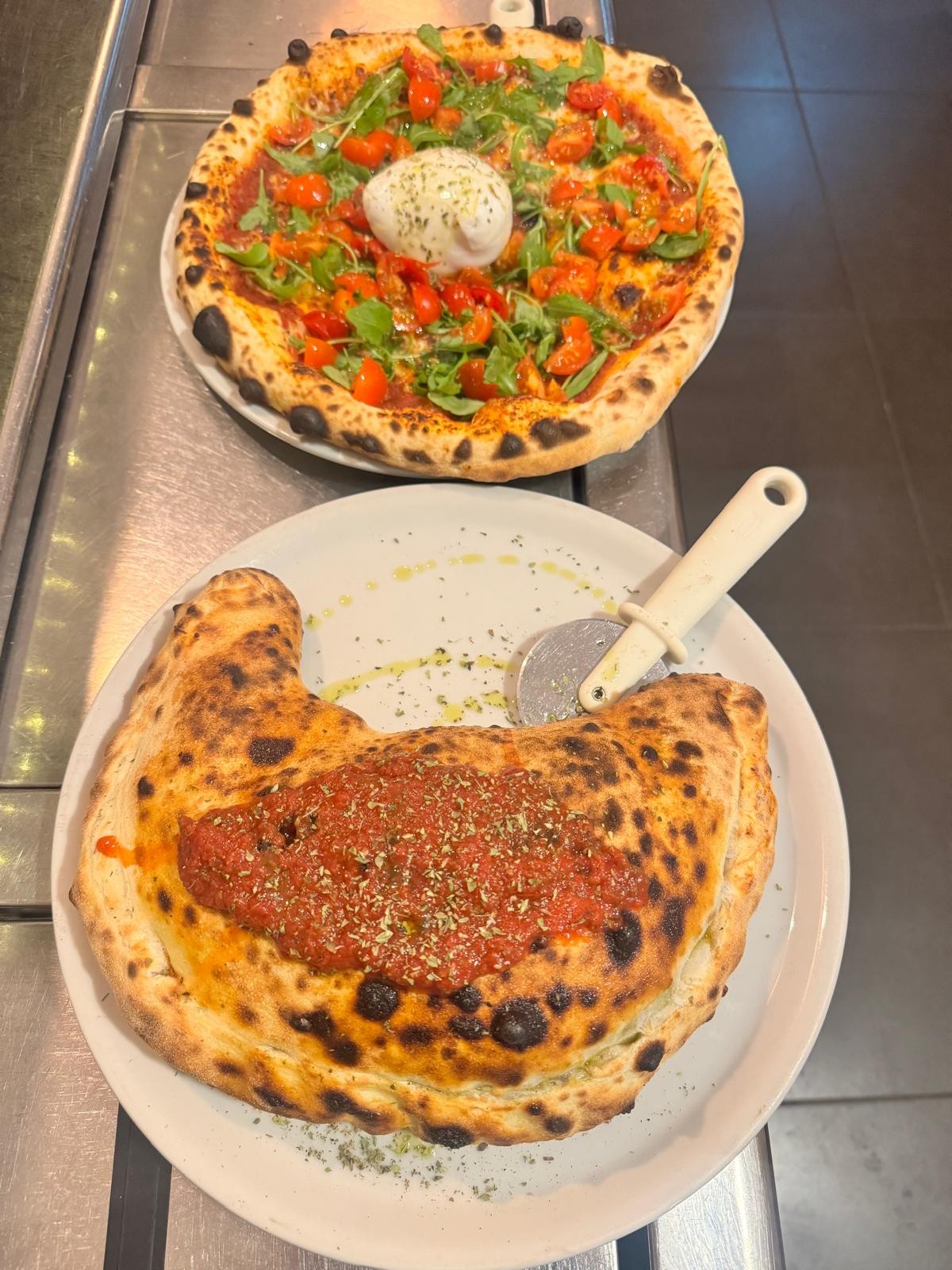 Pizza de burrata y calzone recién hechos en El Botánico de Ramón y Marisol